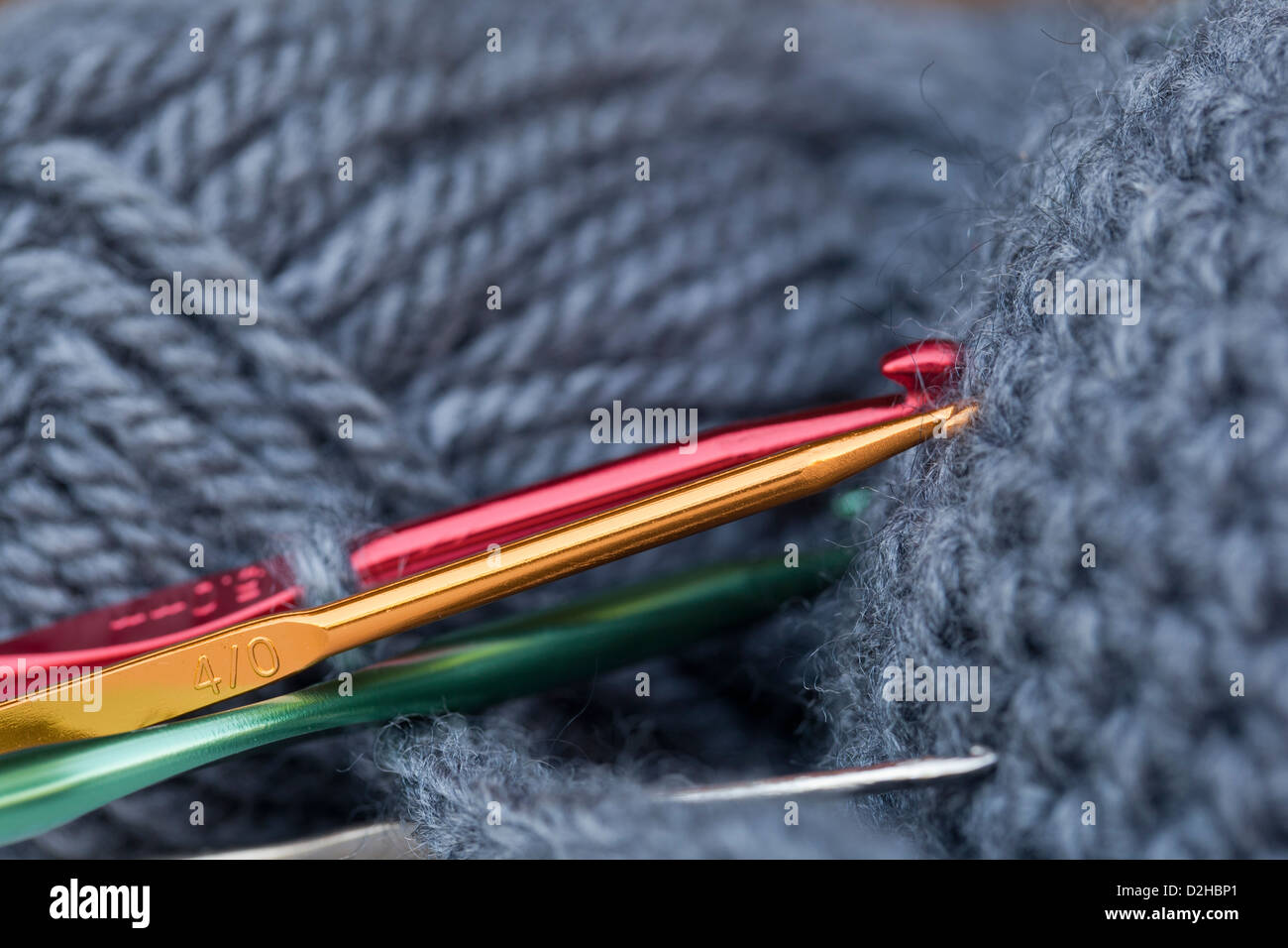 Close-up delle colorate ganci a crochet in un filo grigio. Foto Stock