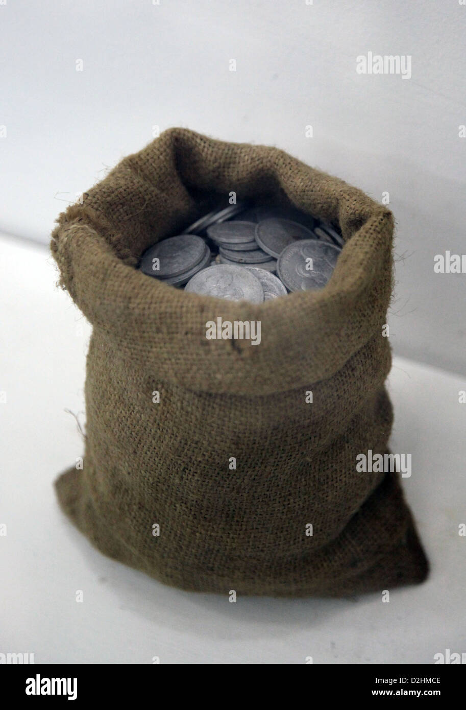 Si tratta di una foto di una piccola busta da tessuti. È piena di monete. Le monete sono in colore grigio argento. Foto Stock