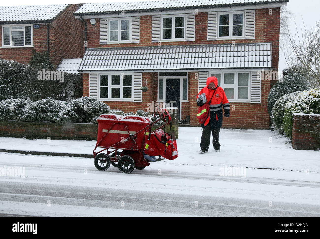 Postino recapita la mail a Londra nel gennaio nevicata. Foto Stock