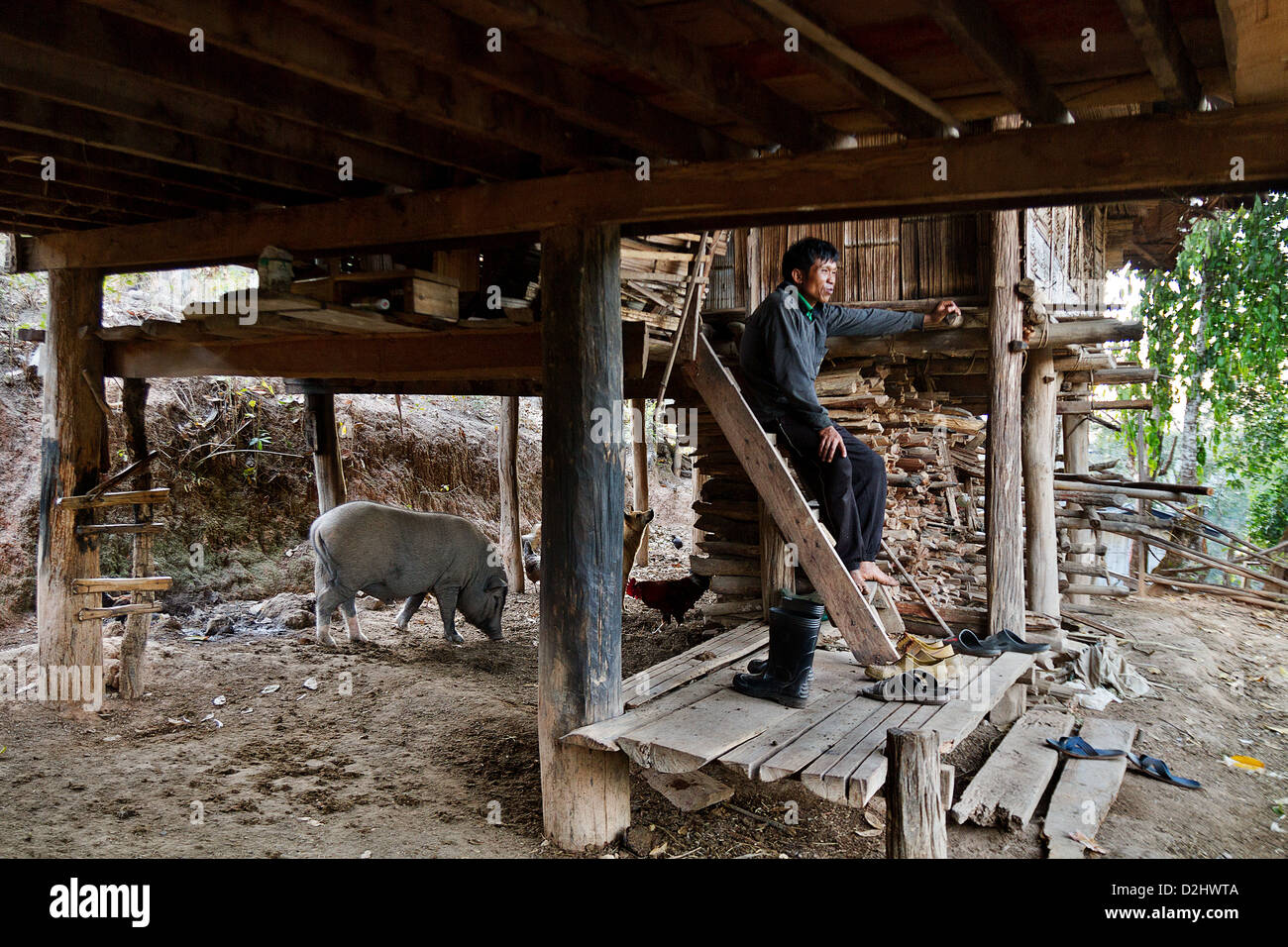 Un uomo in entrata di una casa semplice, villaggio di montagna. Chiang Mai Provincia, Foto Stock