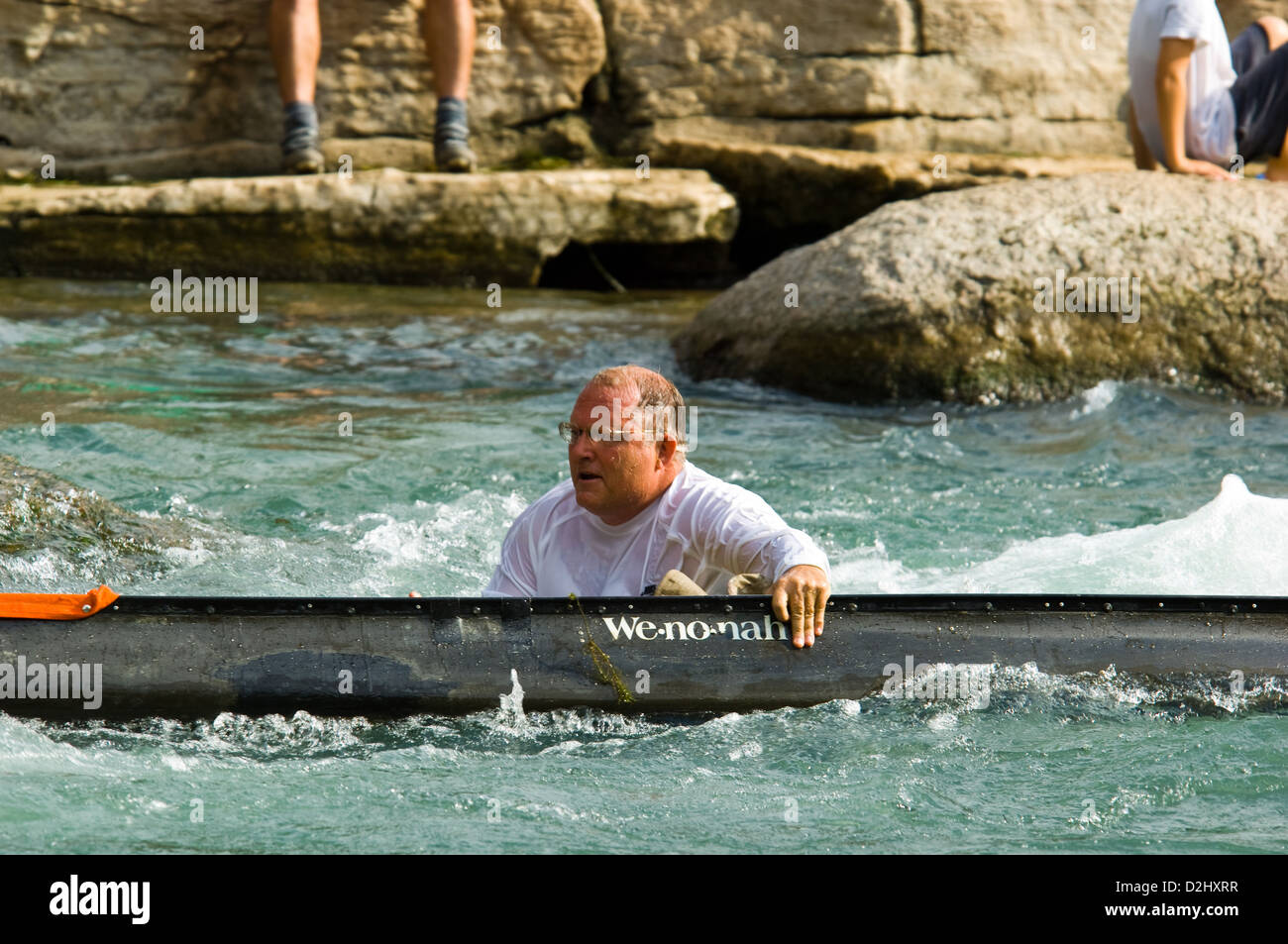 Uomo di nuoto con il suo rovesciamento canoa al Texas acqua canoa Safari gara, San Marcos Texas Foto Stock