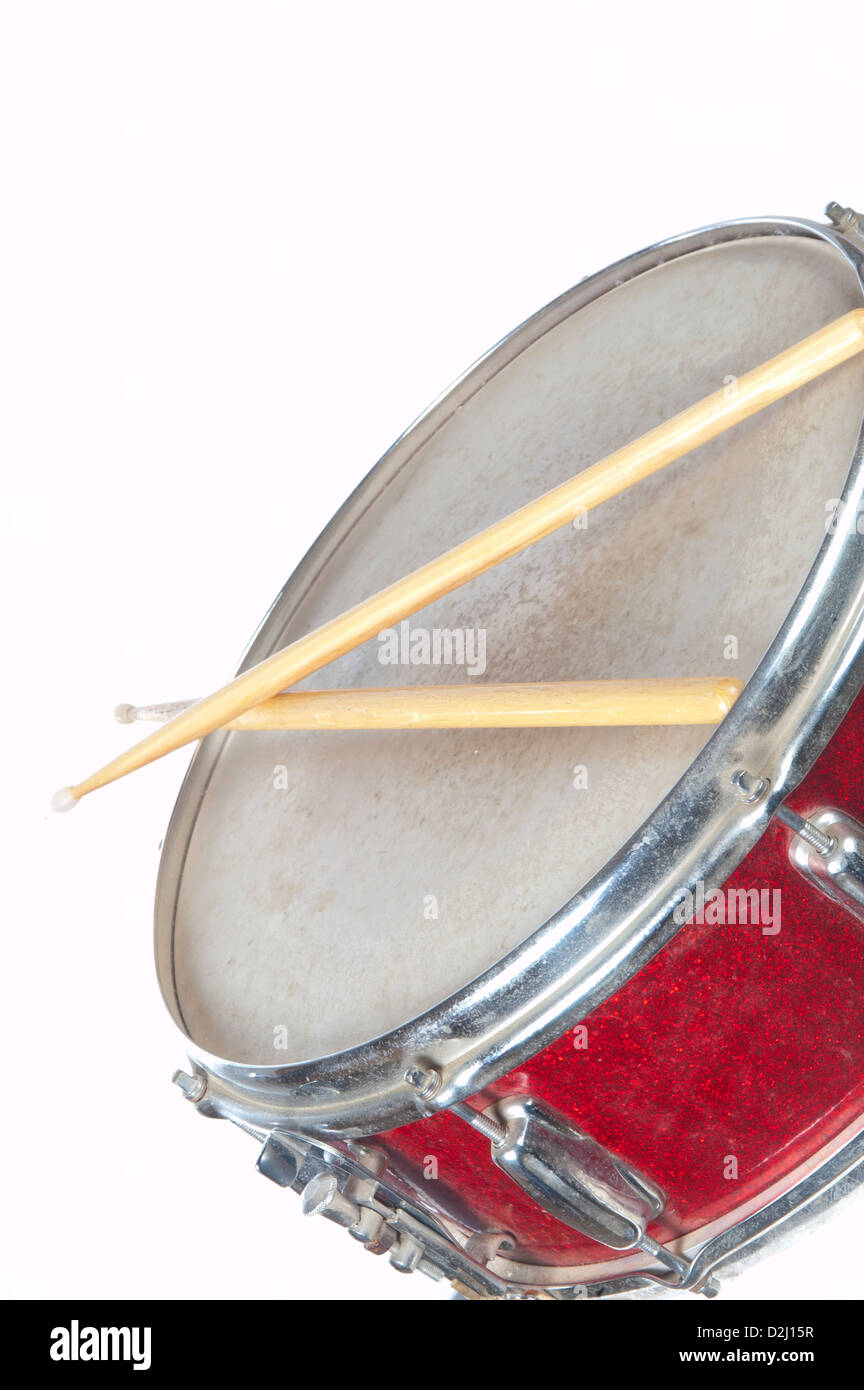 Un rosso snare drum nel profilo con bacchette su uno sfondo bianco. Vi è abbondanza di spazio copia disponibile per il vostro messaggio. Foto Stock