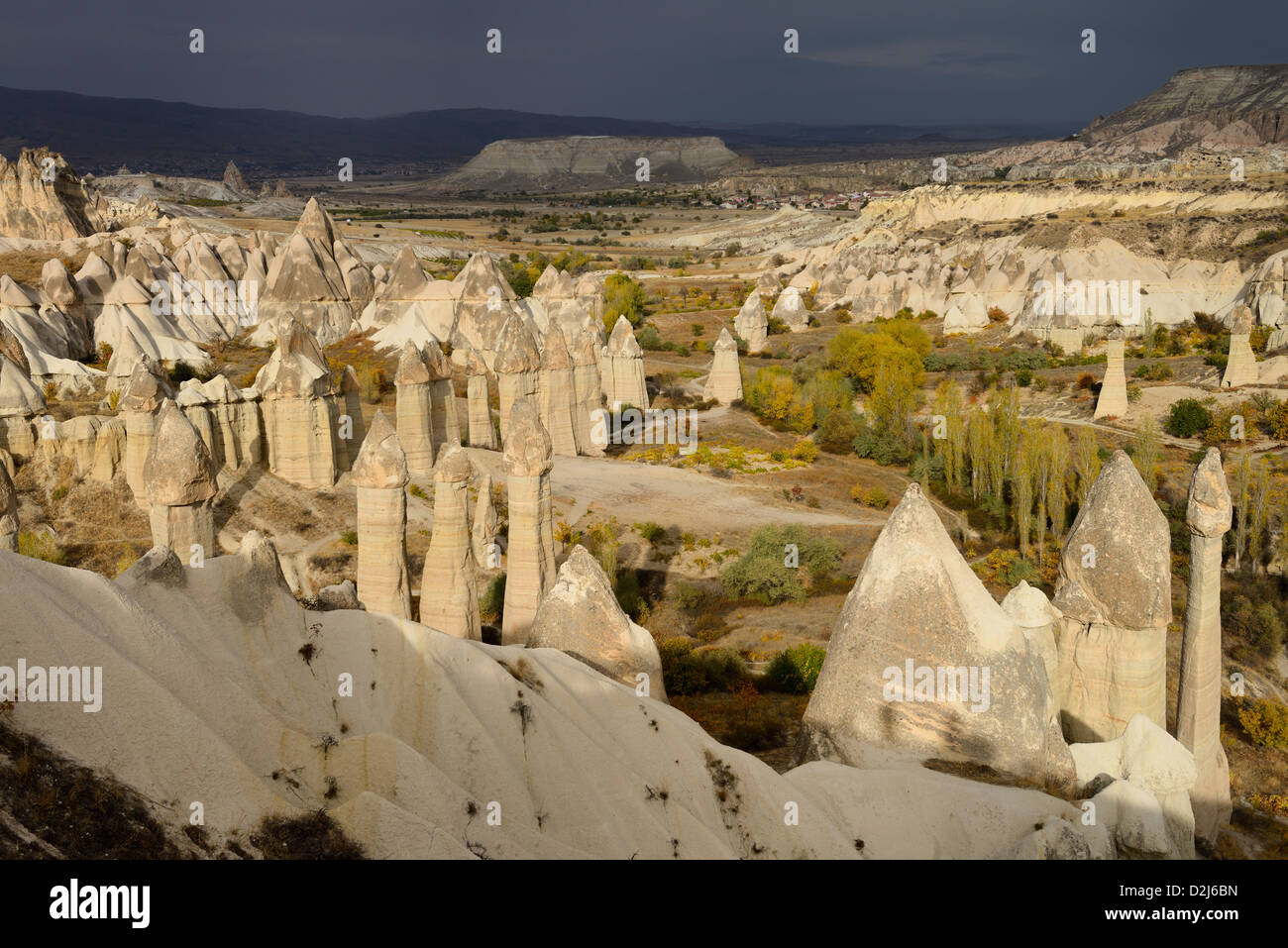 Rottura sole attraverso il fallico Camini di Fata in Love Valley Goreme Parco nazionale della Turchia con Cavusin e Avanos villaggi Foto Stock