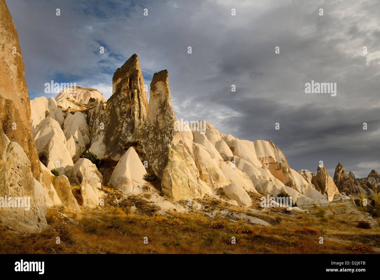 Sole di sera sulle guglie di roccia della Valle di rosso con casa grotta Cappadocia Nevsehir Turchia Foto Stock