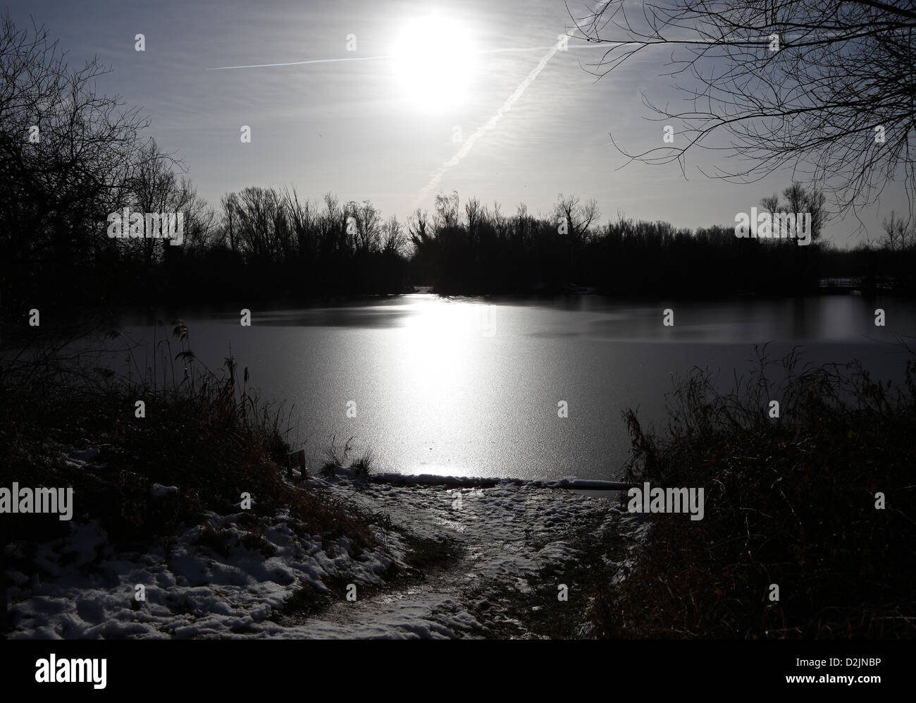 Inverno lago di scena contra-jour mono Milton country park Cambridgeshire Foto Stock