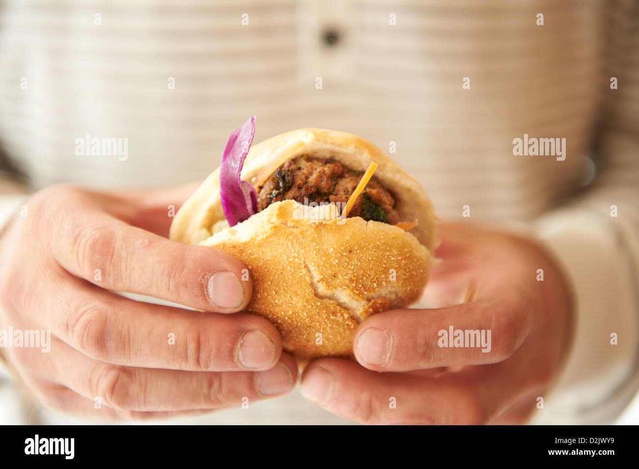 Uomo con piccoli hamburger di manzo Foto Stock