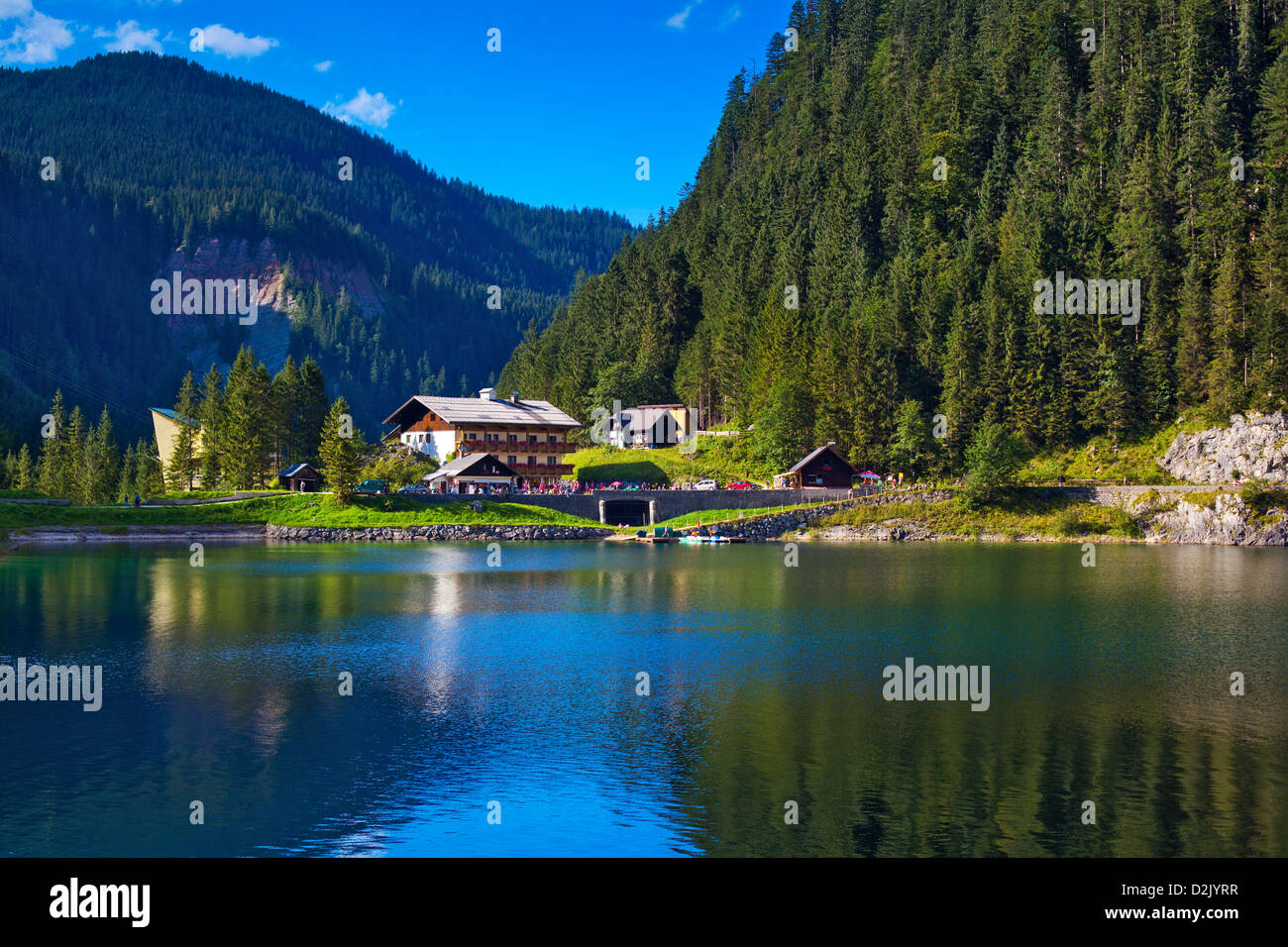 Alpi paesaggio di montagna. Lago e casa in primo piano. Foto Stock