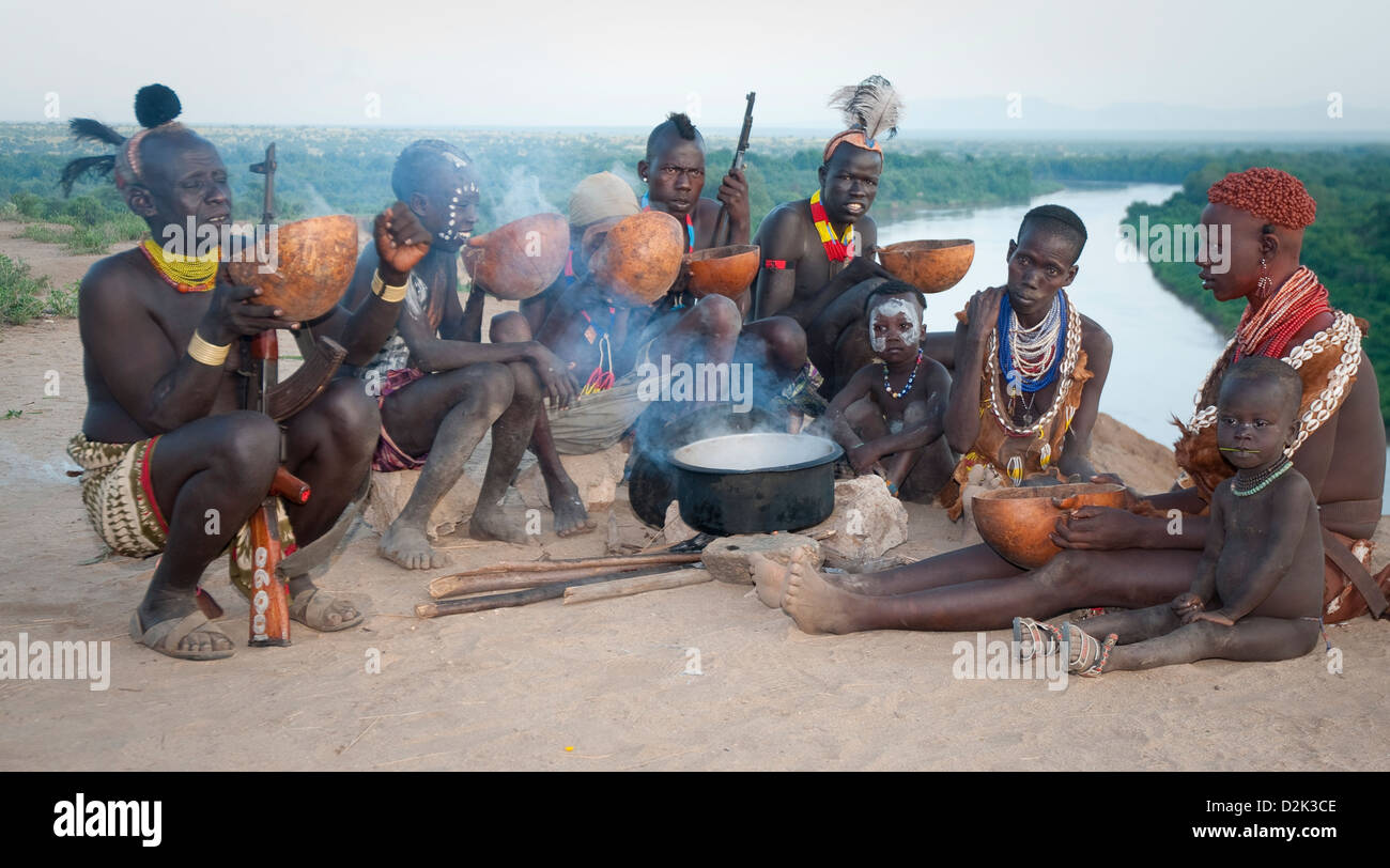 New Scenic 5 posti del gruppo di decorate Kara uomini, donne e bambini intorno al recipiente di cottura-Omo river sotto Foto Stock