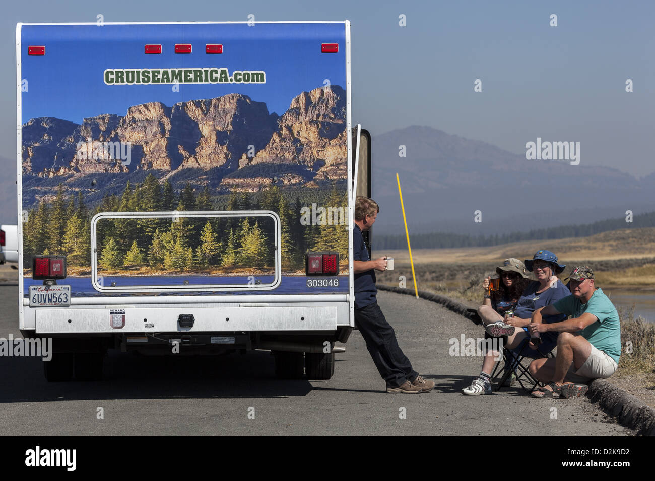 Cruise America affittato motorhome con paesaggio decorato con il rv'ers relax accanto veicolo a Yellowstone Foto Stock