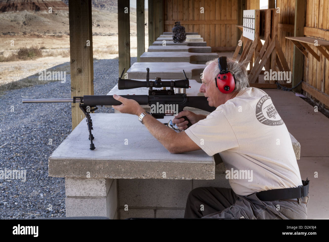 Uomo più anziano di indossare protezioni per l'udito sparando un puledro .223 partita fucile bersaglio, Wyoming USA Foto Stock