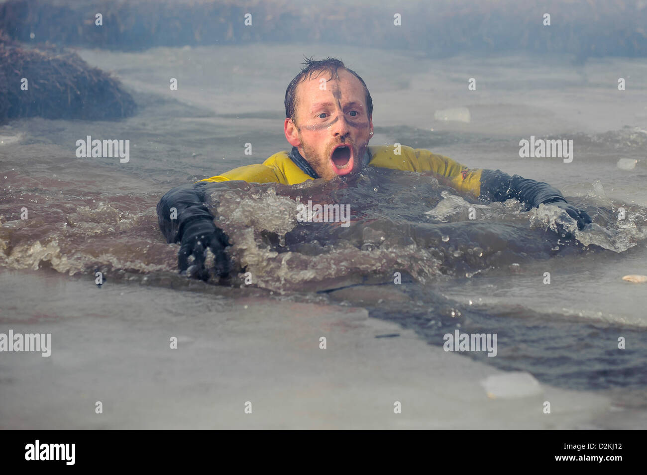 27.01.2013 Perton, Inghilterra. Un challenger wades attraverso il congelamento di acqua ghiacciata al "Battaglia delle Somme' nella sezione di killing fields durante l'edizione invernale del duro a sud Perton Farm. Migliaia di comptitors eseguire il 8 'paese mile' ostacolo corso che include acqua, temperature di congelamento e di incendio. Foto Stock