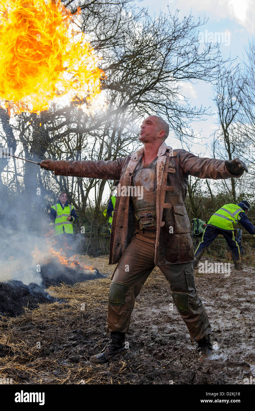 27.01.2013 Perton, Inghilterra. Un challenger vestito come Batman charachter Bane respira incendio presso la "Battaglia delle Somme' sectionin killing fields durante l'edizione invernale del duro a sud Perton Farm. Migliaia di comptitors eseguire il 8 'paese mile' ostacolo corso che include acqua, temperature di congelamento e di incendio. Foto Stock