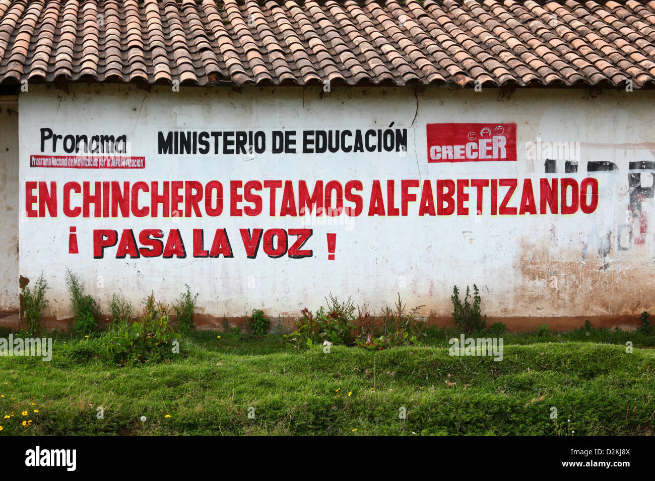 Ministero della Pubblica Istruzione propaganda promuovere rurale di programmi di alfabetizzazione su adobe house wall, Chinchero , vicino a Cusco, Perù Foto Stock