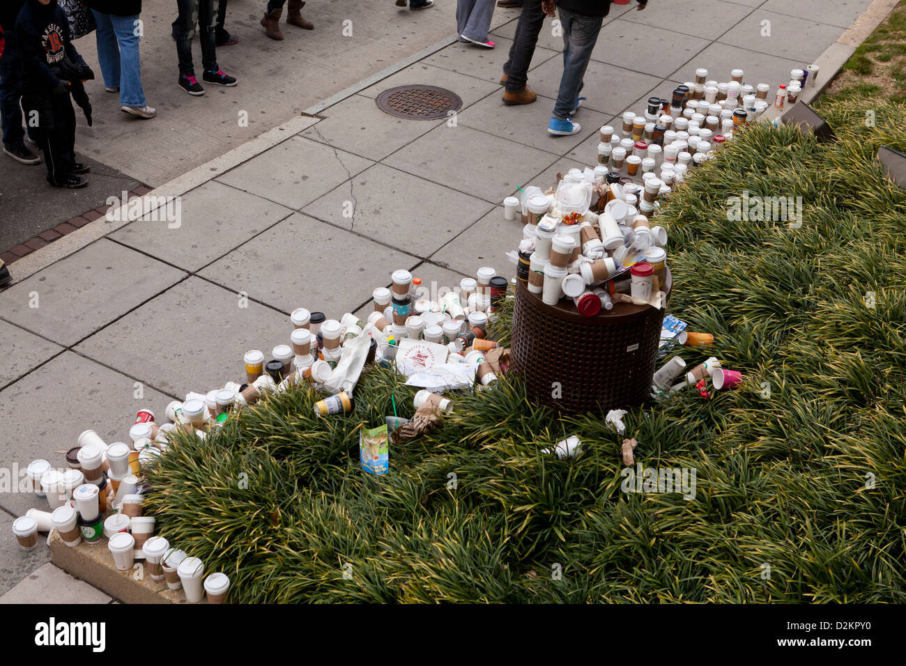 Scartato tazze da caffè trabocca dal cestino su strada pubblica Foto Stock