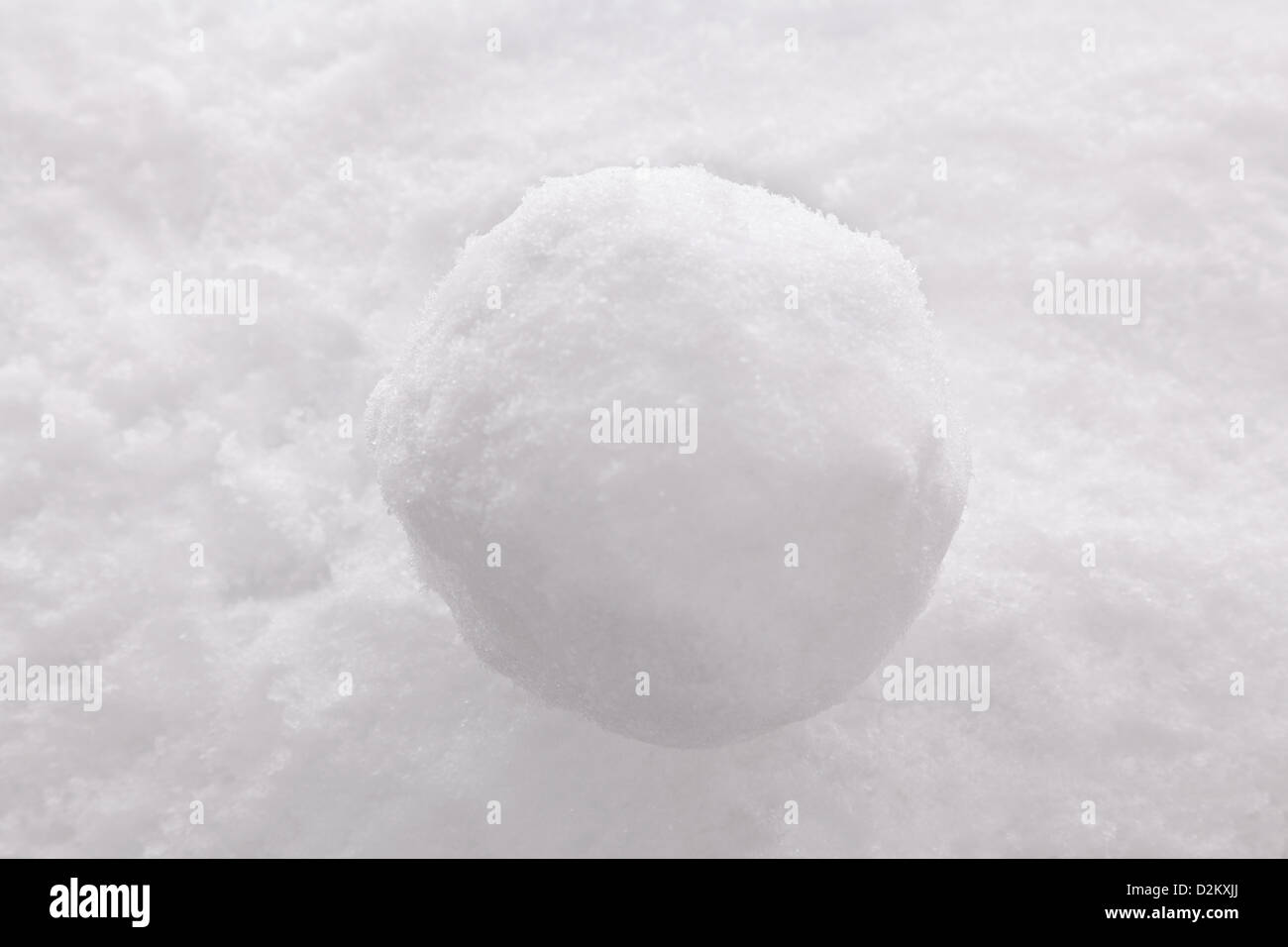 Una sola palla di neve su un sfondo di neve. Foto Stock