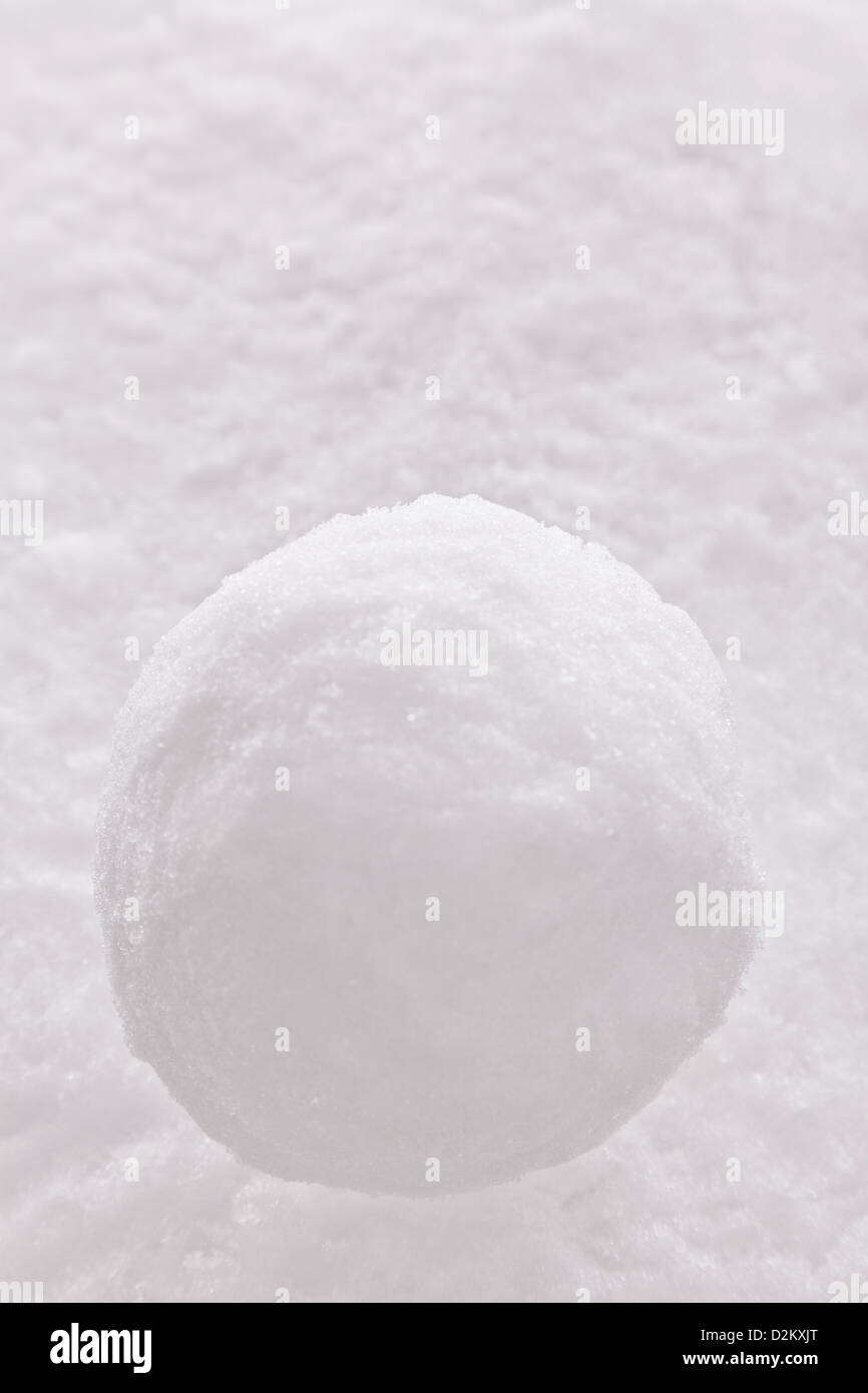 Una sola palla di neve su un sfondo di neve. Foto Stock