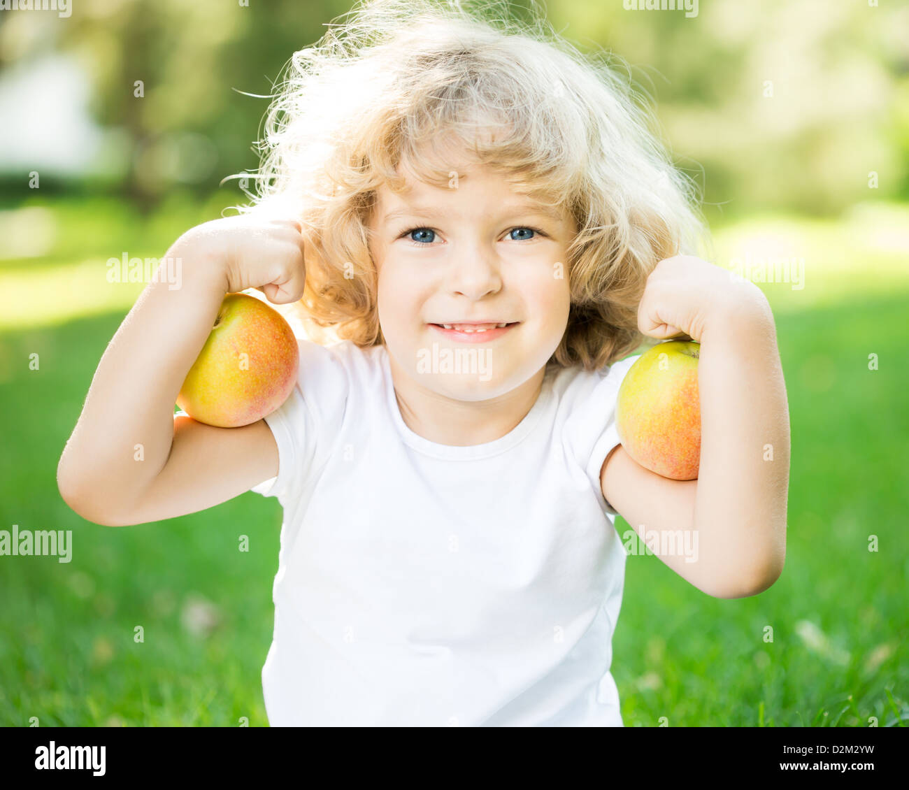 Bambino felice giocando con mele all'aperto nella primavera del parco. Concetto di fitness Foto Stock