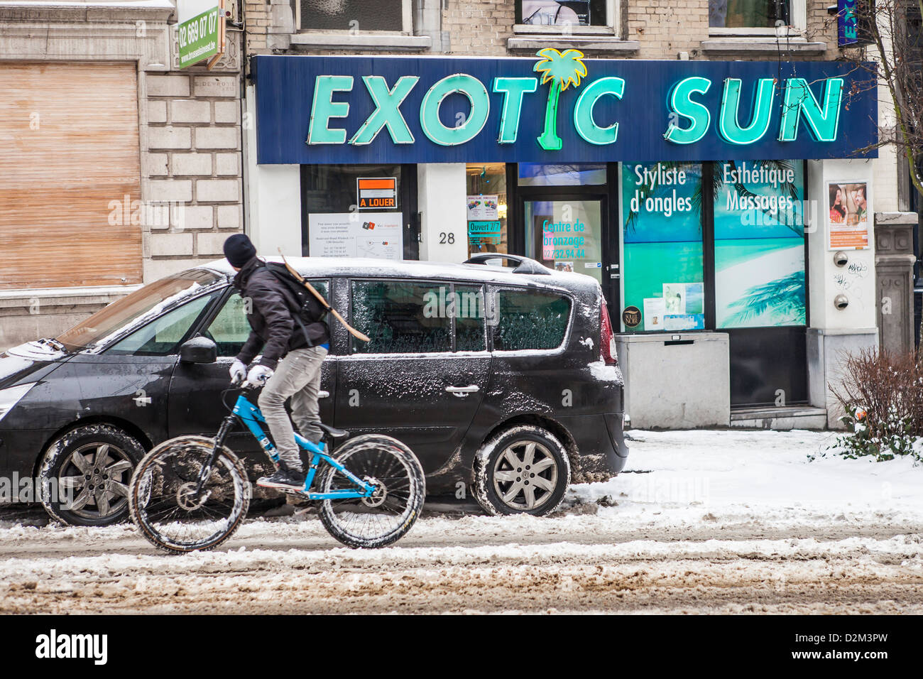Un ragazzo vanno in bicicletta in un giorno di neve a Bruxelles, in Belgio Foto Stock