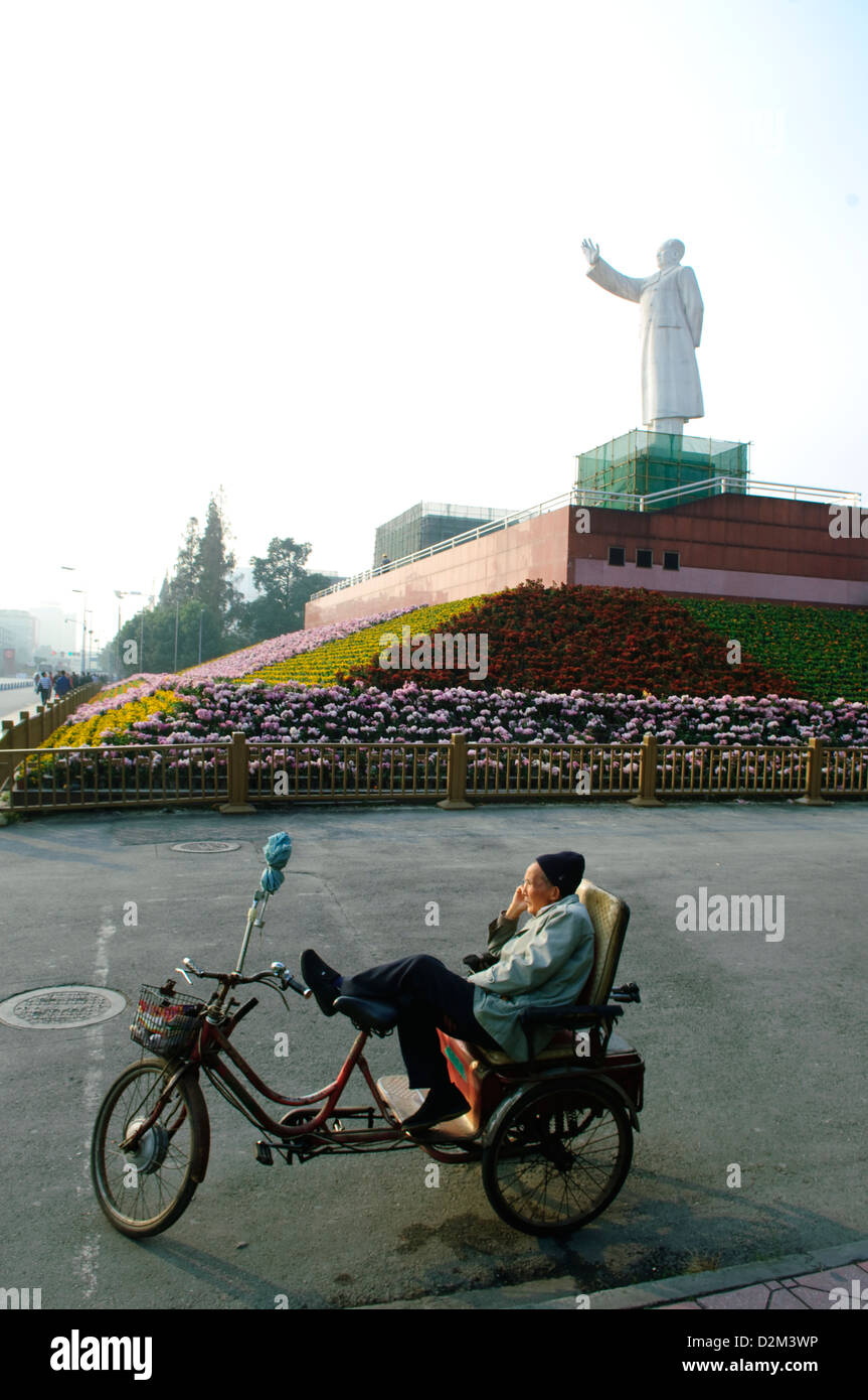 Uomo seduto su una moto sotto mao statua, Cina Foto Stock