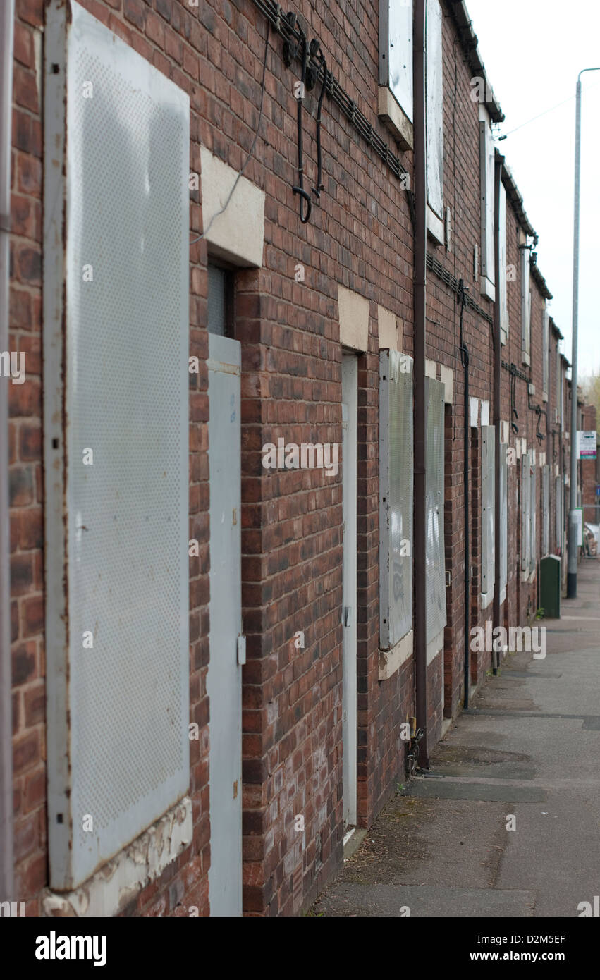 Una fila di ex case colliery intavolato e pronta per i lavori di demolizione a Pleasley, Mansfield, Nord Nottinghamshire. Foto Stock