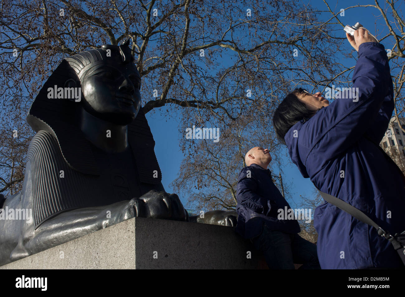 Un viaggio di gruppo organizzato da WalkLondon fermare da una sfinge a conoscere le antiche obelisco egiziano noto come Cleopatra Needle, sul terrapieno WC2. Cleopatra Needle è fiancheggiato da due faux-Egiziana sfingi espressi dal bronzo che recano iscrizioni geroglifiche che dire netjer nefer uomini-kheper-re di ankh (il buon Dio, Thuthmosis III dato vita). Queste sfingi sembrano essere guardando l'ago piuttosto che a guardia di esso. Questo è dovuto al fatto che le sfingi' impropria o all'indietro l'installazione. Foto Stock