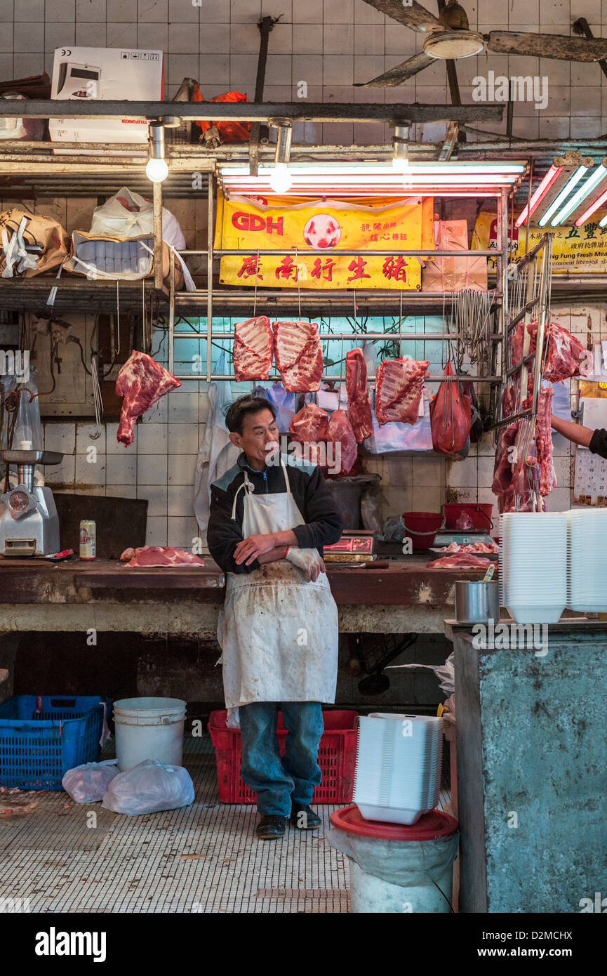 Butcher nel suo negozio di macellaio su Des Voeux Road (pesce essiccato Street), Sheung Wan, Hong Kong. Foto Stock