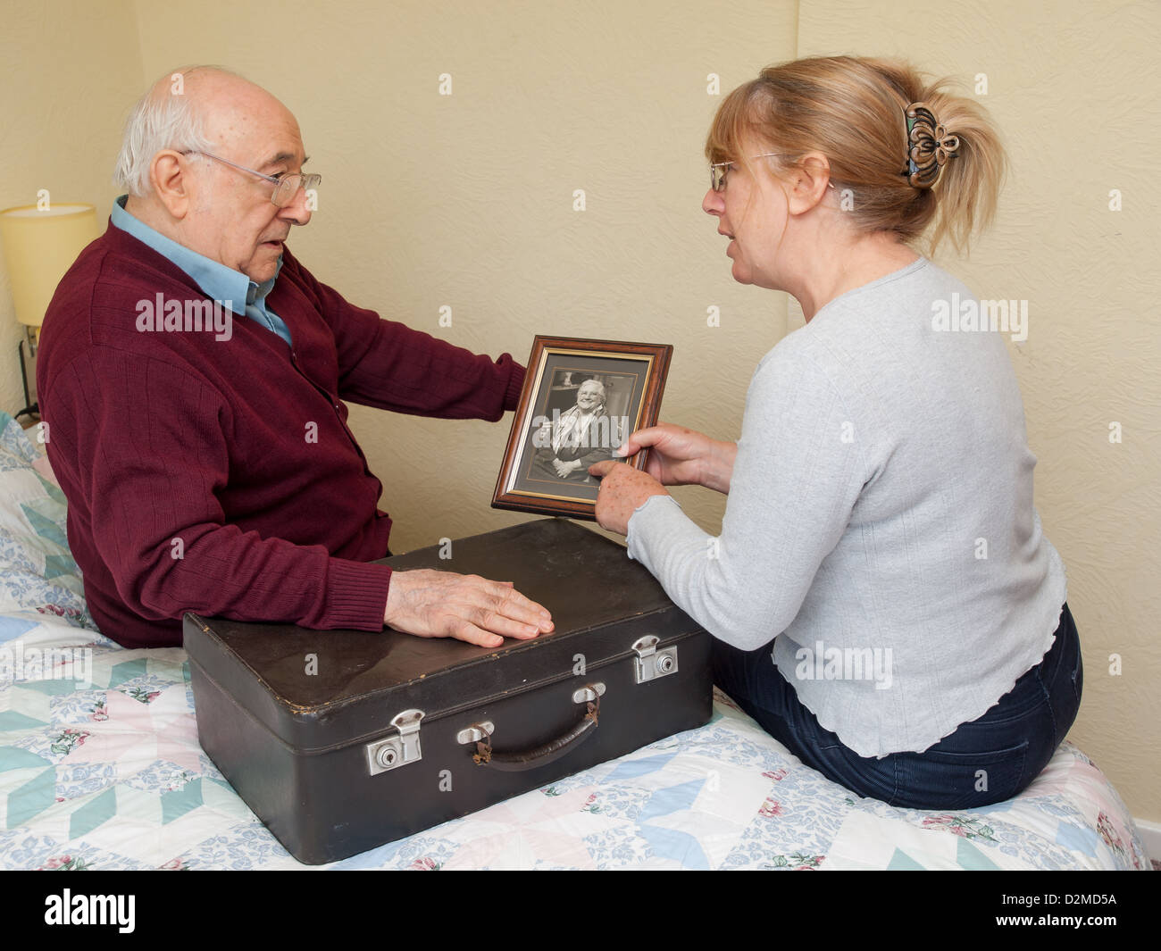 Uomo anziano con la figlia guardando fotografia Foto Stock