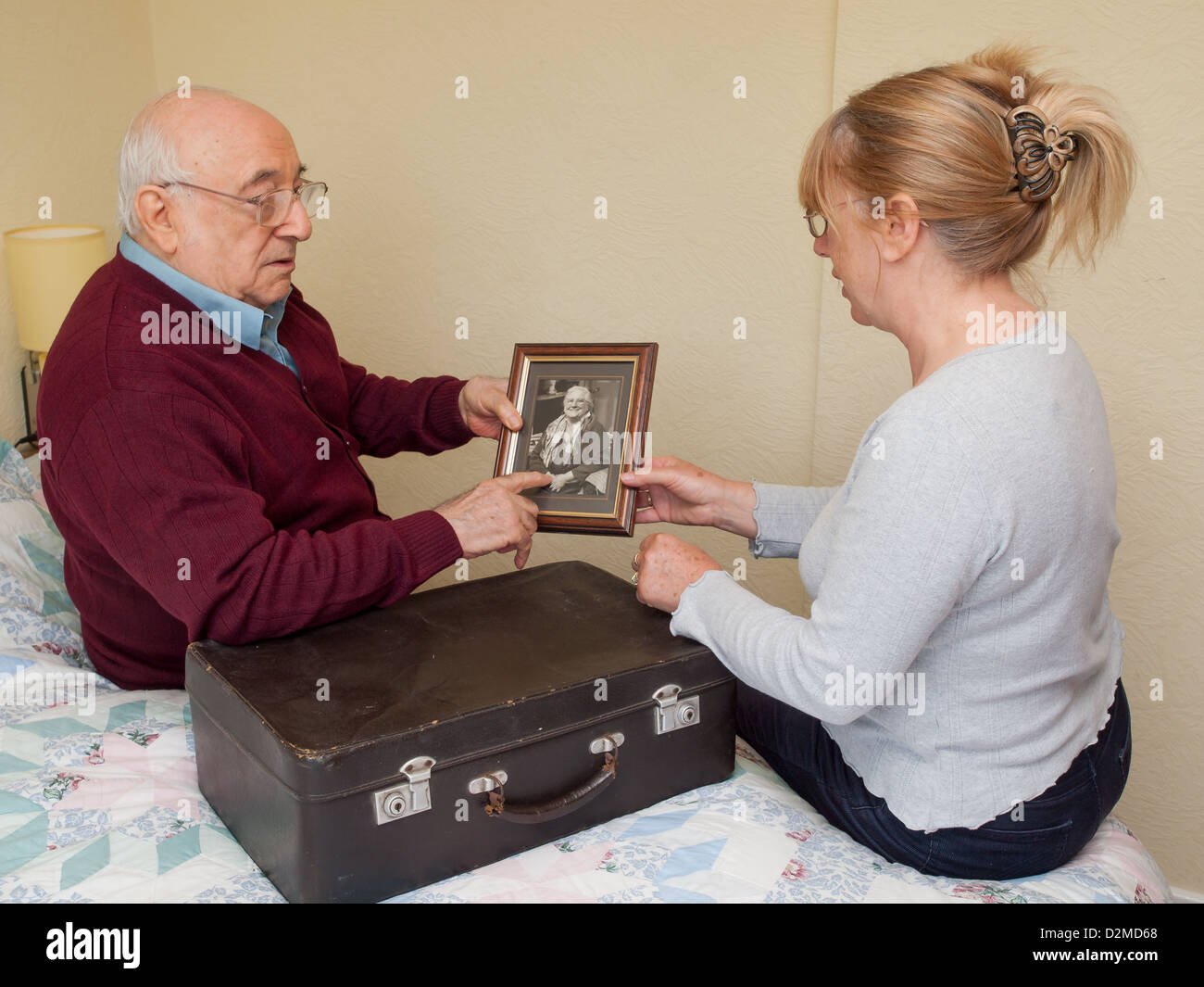Uomo anziano con la figlia guardando fotografia Foto Stock