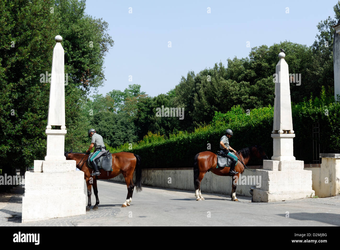 Roma. L'Italia. Vista di due agenti di polizia su cavalli marrone accanto a due piccoli obelischi presso i Giardini di Villa Borghese, Foto Stock