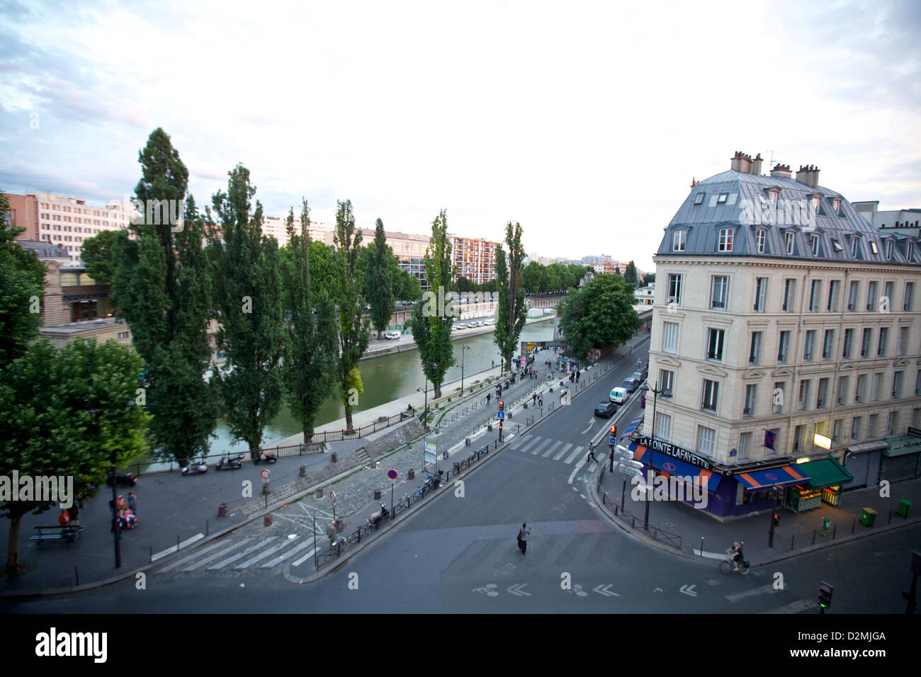 Affacciato sul Canal Saint-Martin da una finestra del Love Hostel di Parigi, Francia, che cattura una vivace scena urbana con canali alberati Foto Stock