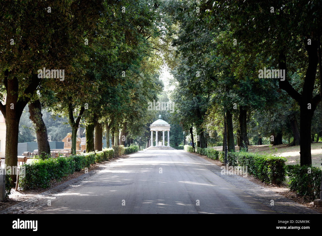 Roma. L'Italia. Viale alberato sentiero conduce alla circolare tempio dedicato a Diana (Tempio di Diana). I giardini di Villa Borghese. Foto Stock