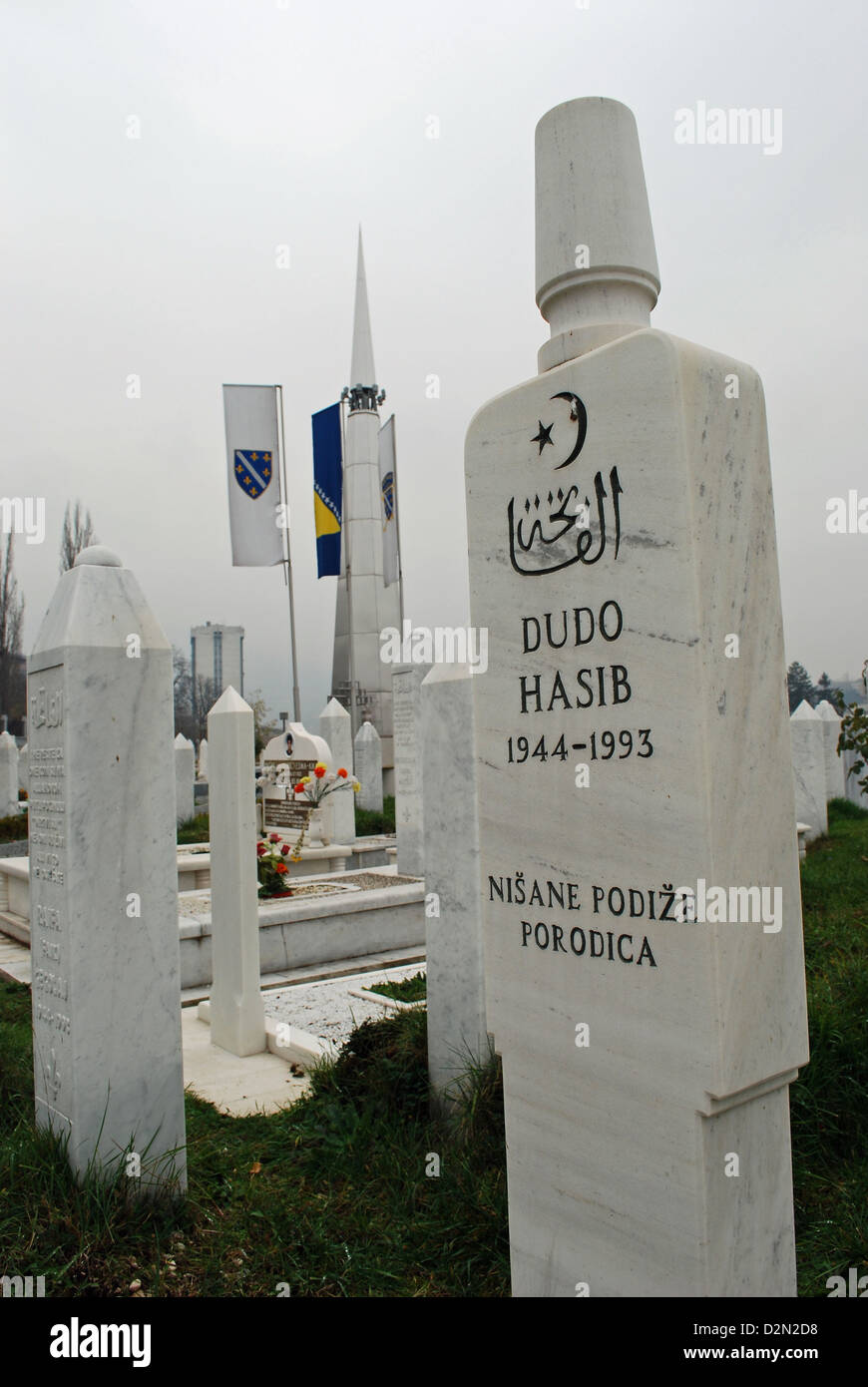 Guerra musulmani tombe nel cimitero di Koševo, Sarajevo. Shahid dei martiri memorial in background. Foto Stock