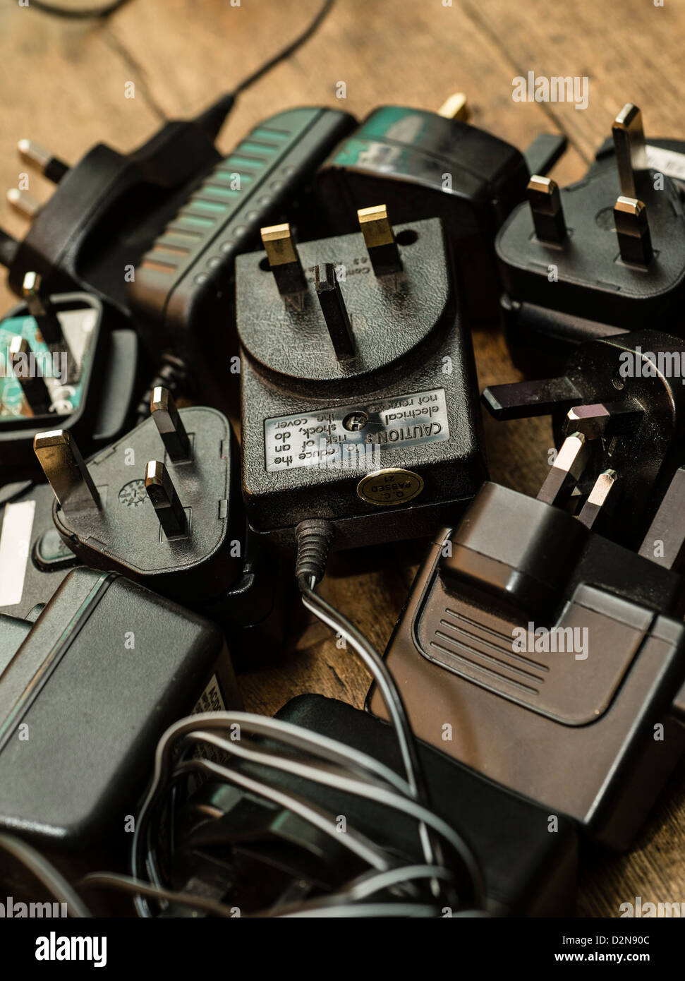 Un mucchio di ridondante vecchio caricabatterie per telefoni cellulari e altri dispositivi elettrici adattatori di alimentazione UK Foto Stock