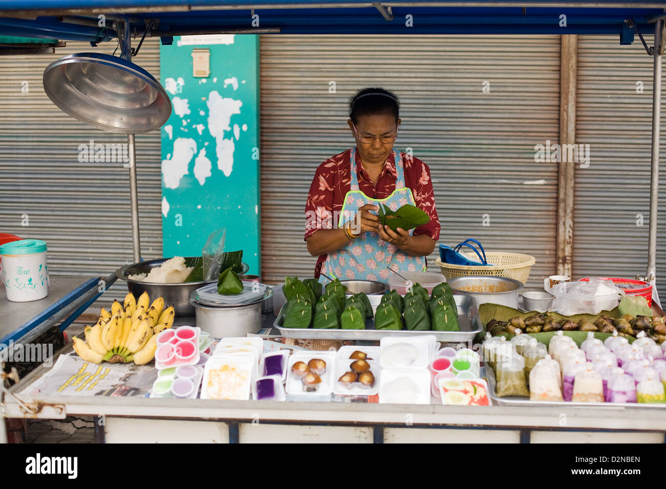 Una donna vende cibo dolce su un mercato in Thong Sala , Koh Phangan , della Thailandia Foto Stock