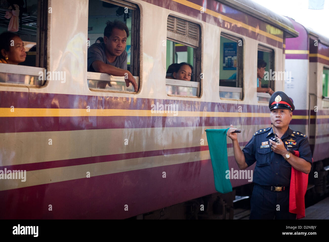 Passeggeri guarda al di fuori di un carrello del treno in corrispondenza di Surat Thani stazione ferroviaria , della Thailandia . Una guardia dei segnali che il treno può lasciare Foto Stock