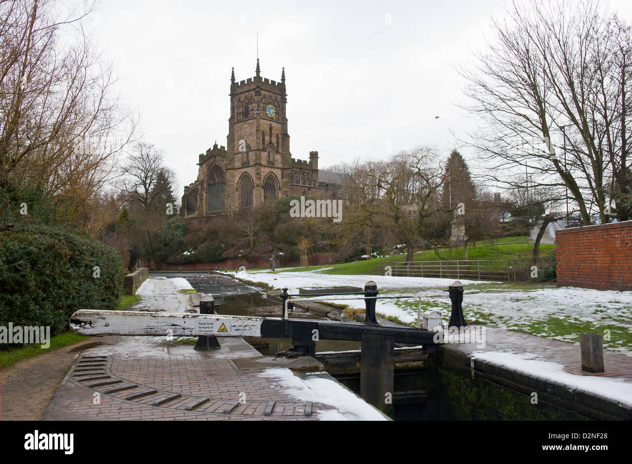 Staffordshire e Worcestershire Canal a Kidderminster in inverno. Congelati canal e cancelli di blocco. St Marys e di tutti i santi della Chiesa Foto Stock