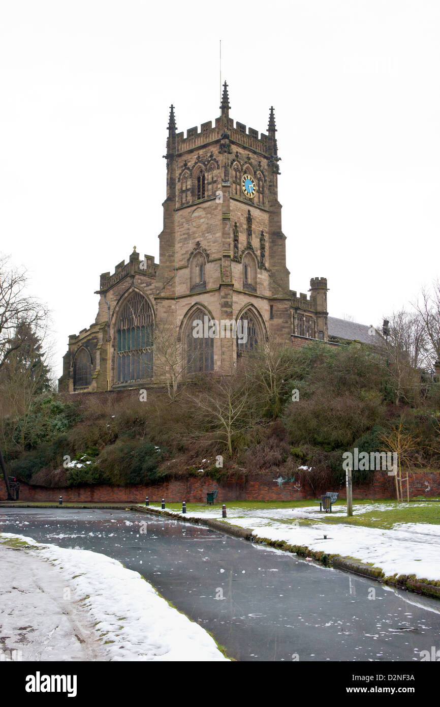 Staffordshire e Worcestershire Canal a Kidderminster in inverno. Congelati canal e cancelli di blocco. St Marys e di tutti i santi della Chiesa Foto Stock