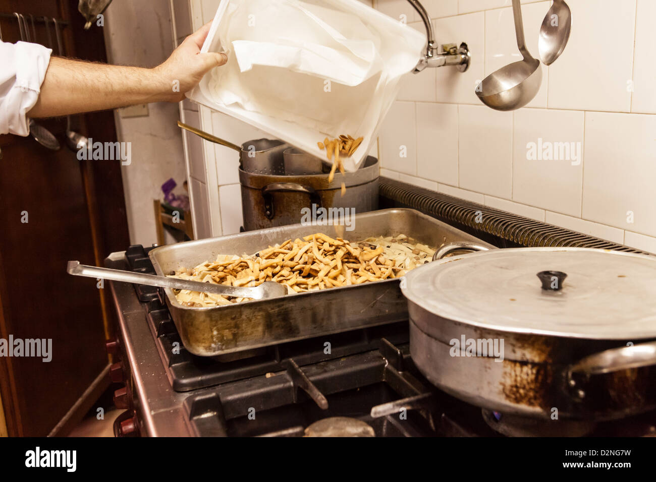 Rendendo Cicere e trie, un piatto tradizionale della regione della Puglia in Italia meridionale. Un mix di pasta fritti e pasta bollita Foto Stock