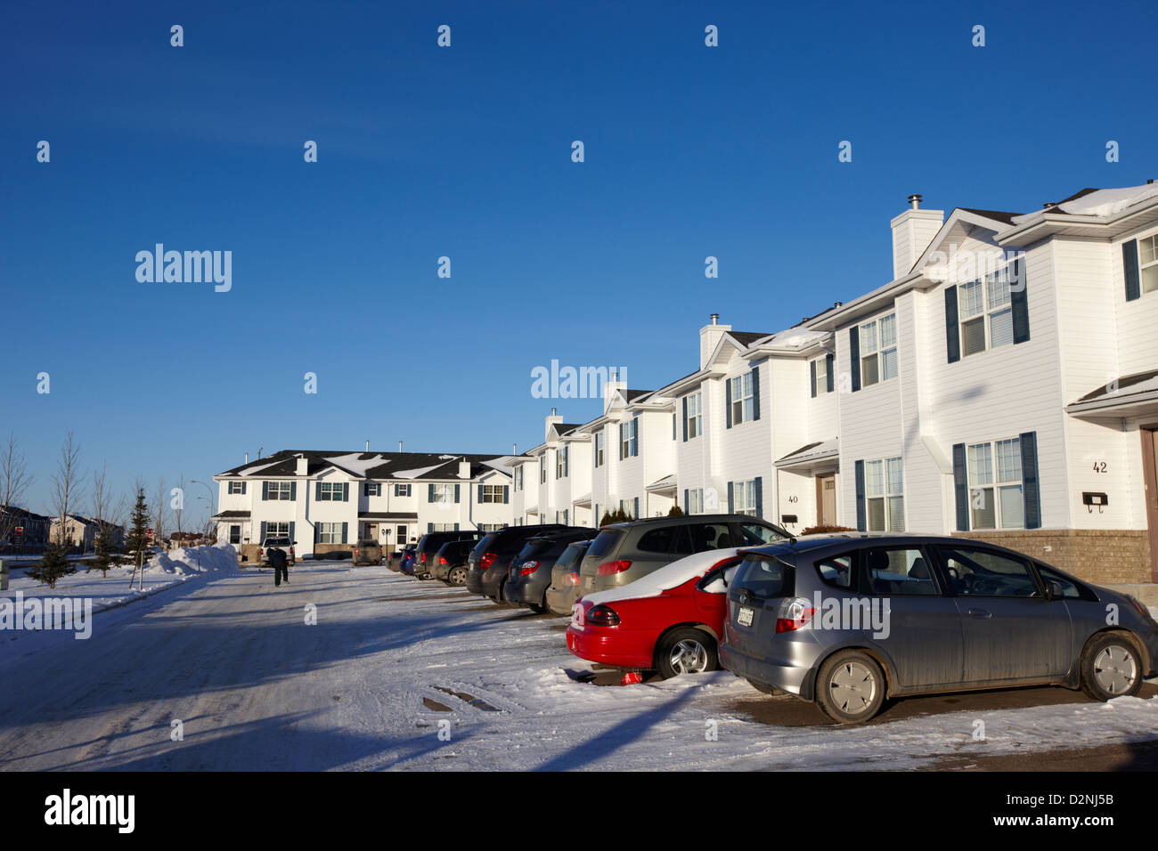 Parcheggio esterno con i veicoli fuori fila di condominio case del motorino di avviamento durante l'inverno Saskatoon Saskatchewan Canada Foto Stock