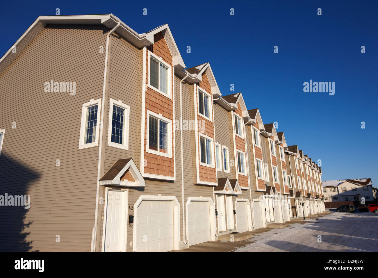 Fila di condominio case del motorino di avviamento durante l'inverno Saskatoon Saskatchewan Canada Foto Stock