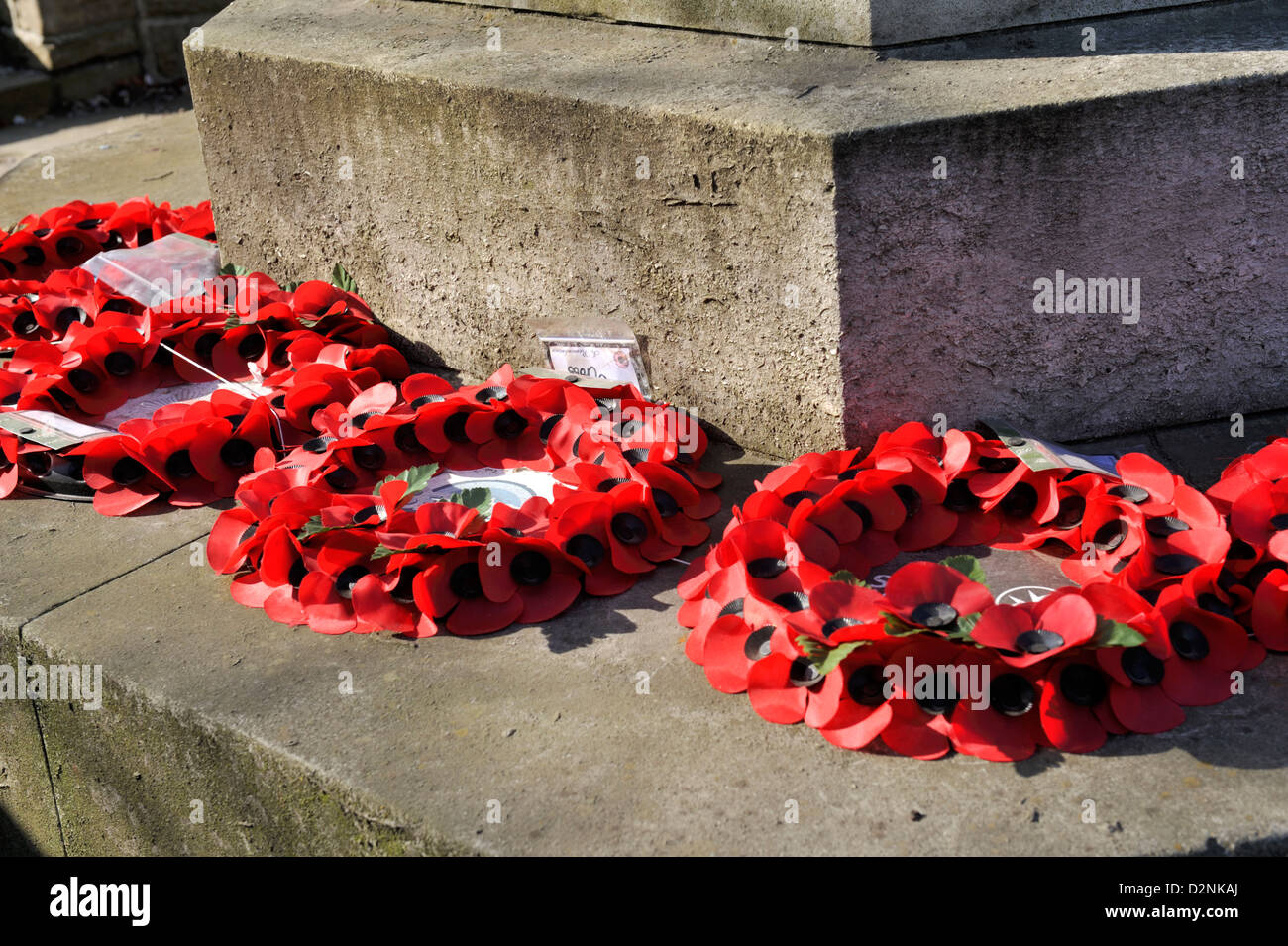 Il papavero ghirlande prevista sul memoriale di guerra Foto Stock