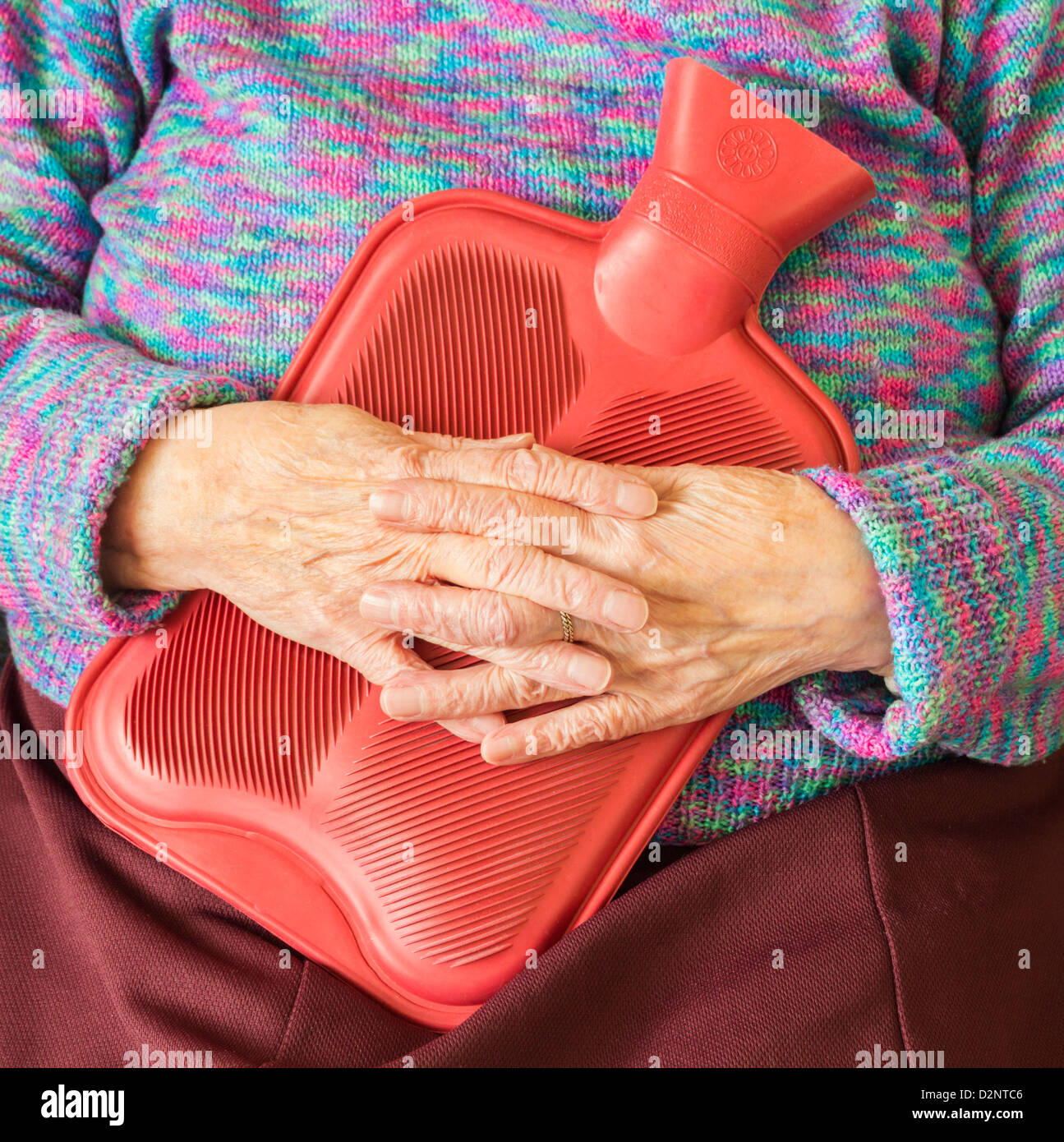 Titolare di pensione o di rendita mantenendo calda con bottiglie di acqua calda in inverno Foto Stock