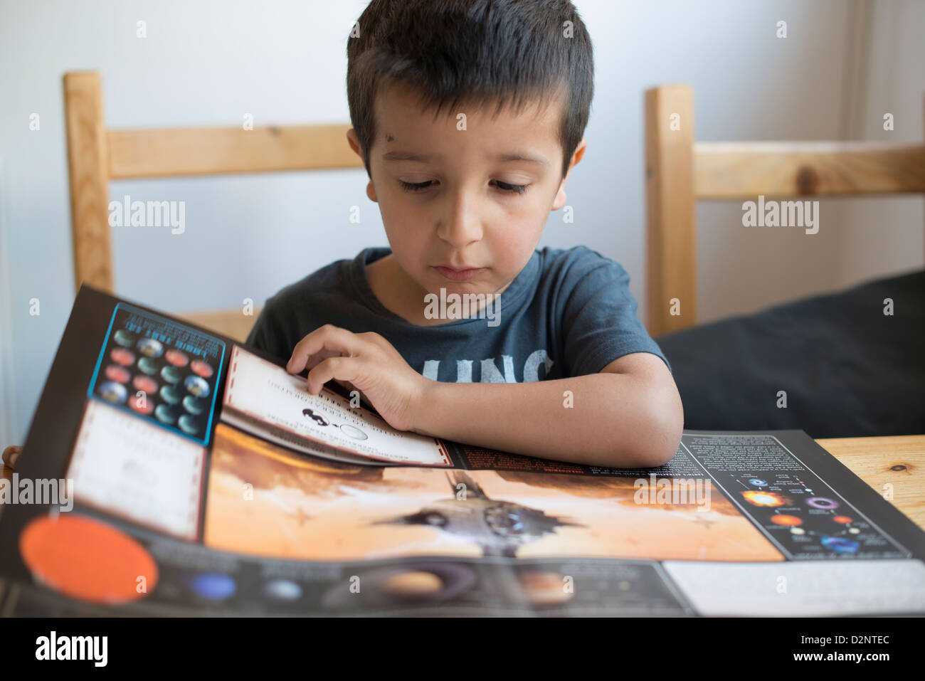 5 anno vecchio ragazzo legge un libro sui pianeti Foto Stock
