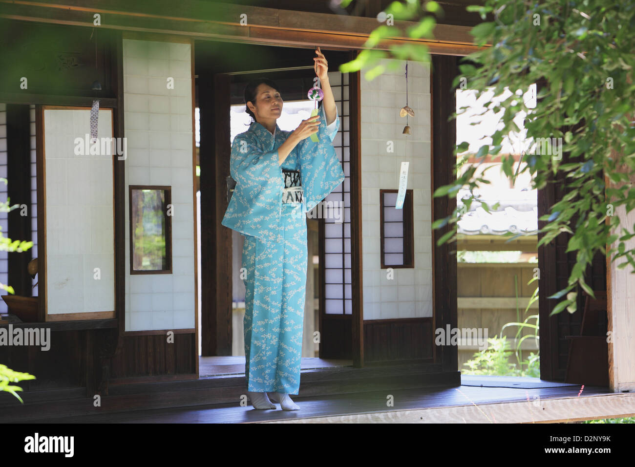 La donna in un kimono con scacciapensieri Foto Stock