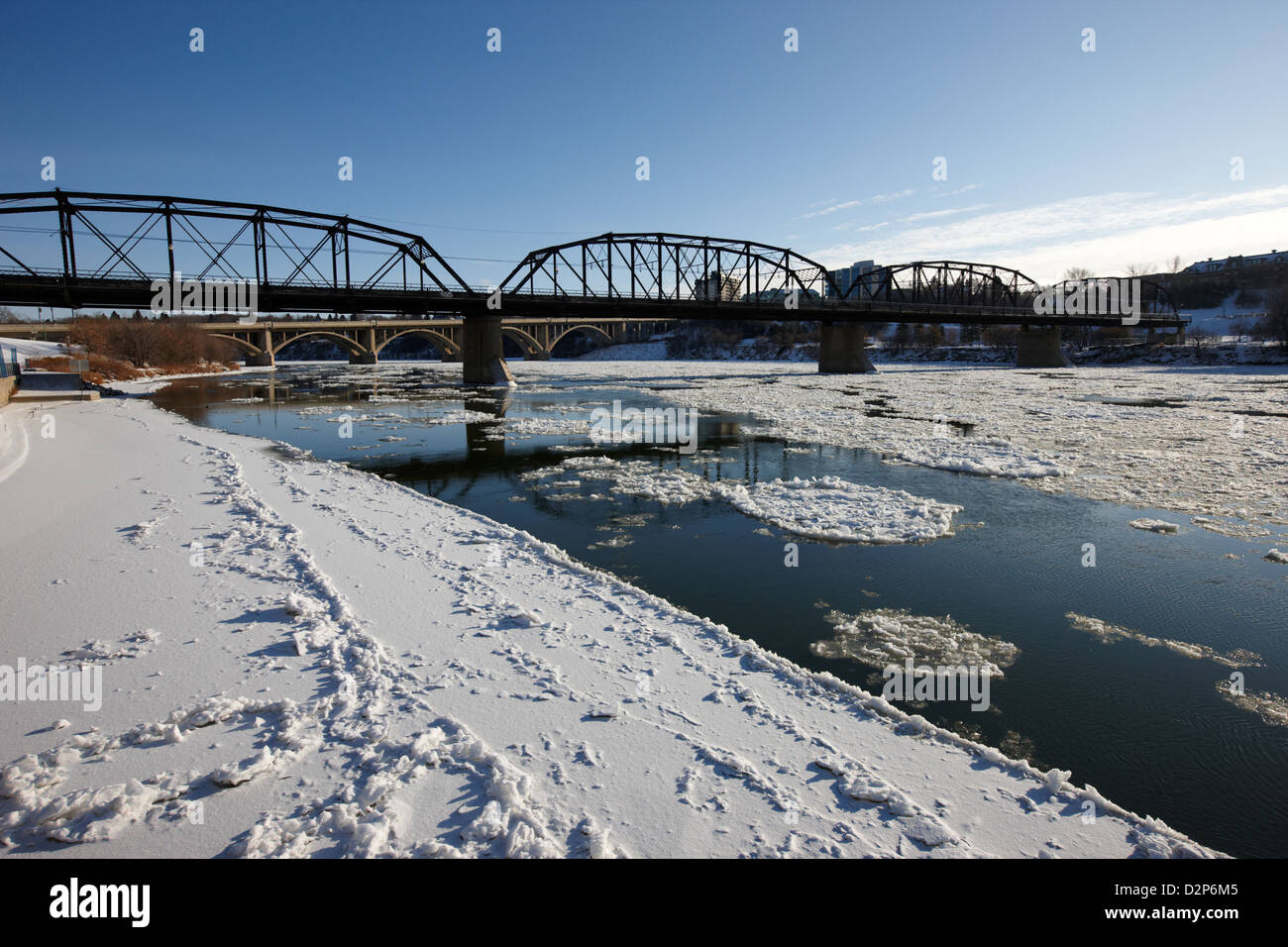 centro di saskatoon città neve freddo inverno congelamento sotto sub zero sud saskatchewan flusso fiume che scorre sotto il vecchio ponte di traffico Foto Stock