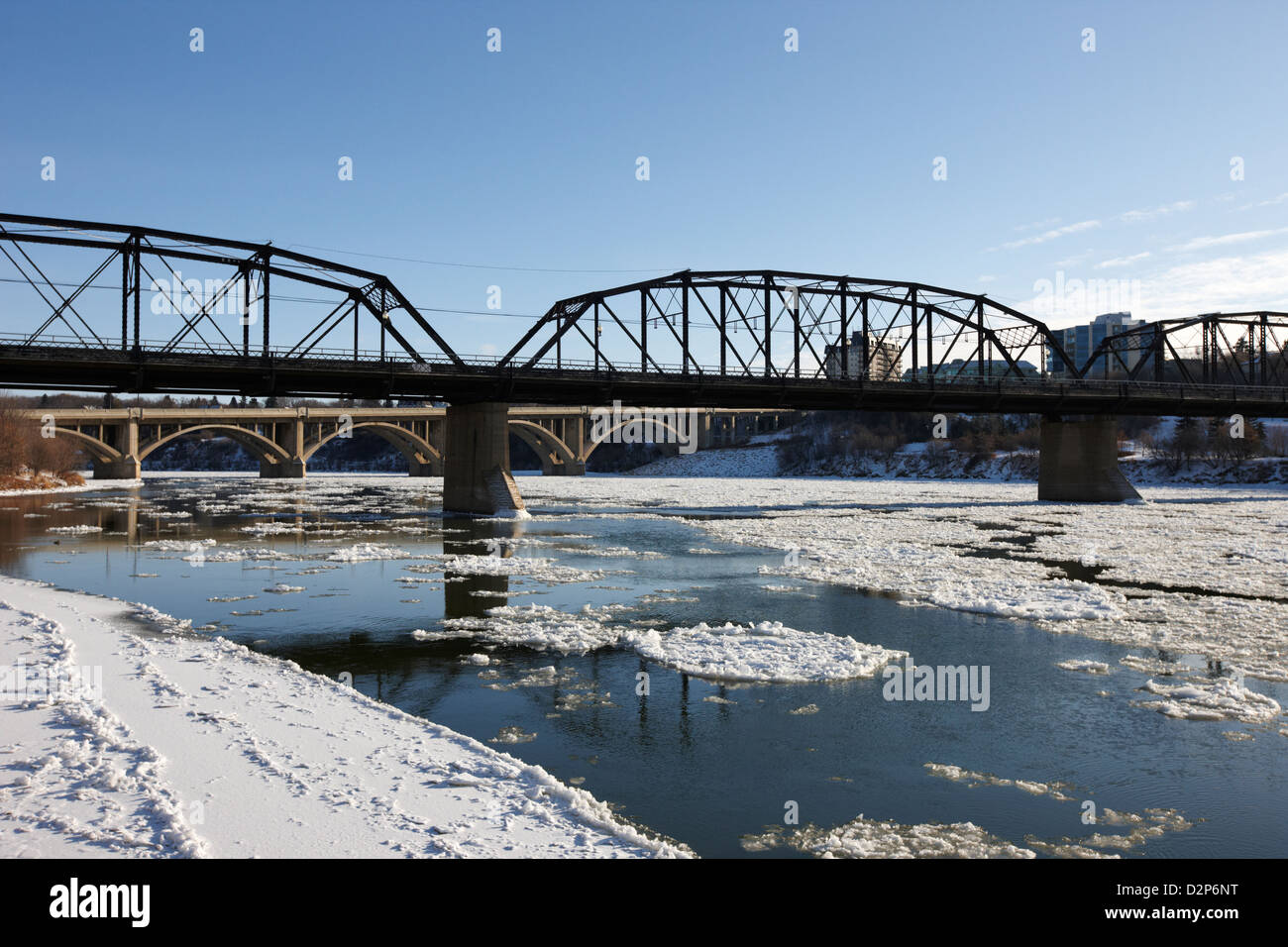 Il vecchio traffico e broadway ponti sul sud del Fiume Saskatchewan in inverno che scorre attraverso il centro cittadino di Saskatoon Saskatchewan Foto Stock