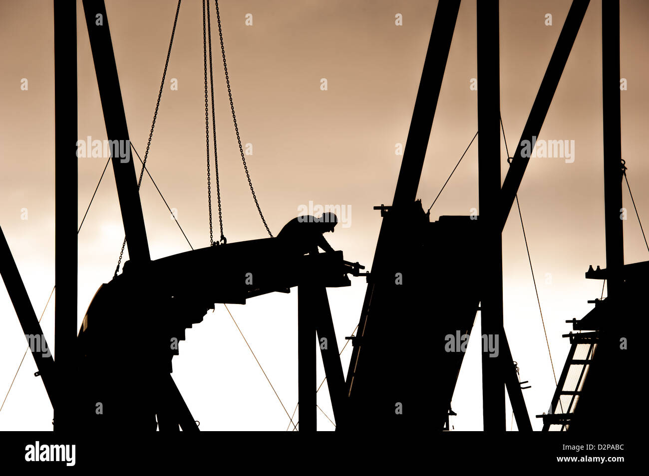 Silhouette di un lavoratore su impalcatura per la costruzione di fiera ride Foto Stock