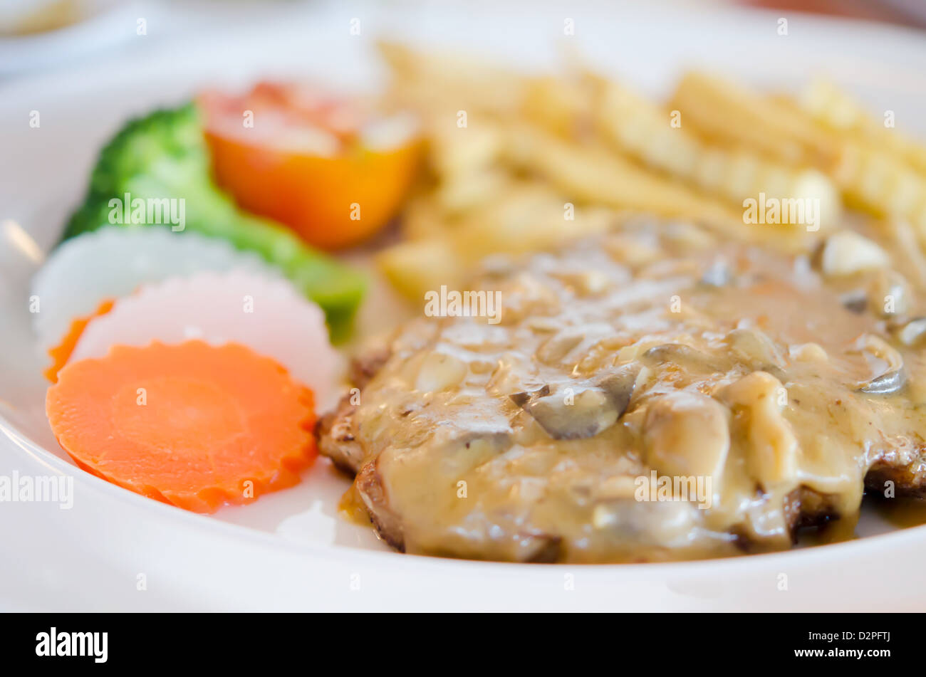 Bistecca di manzo con salsa di funghi e verdure sulla piastra Foto Stock