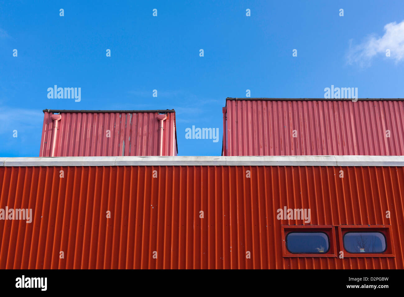 Edificio rosso contro il cielo blu con soffice nuvola Foto Stock