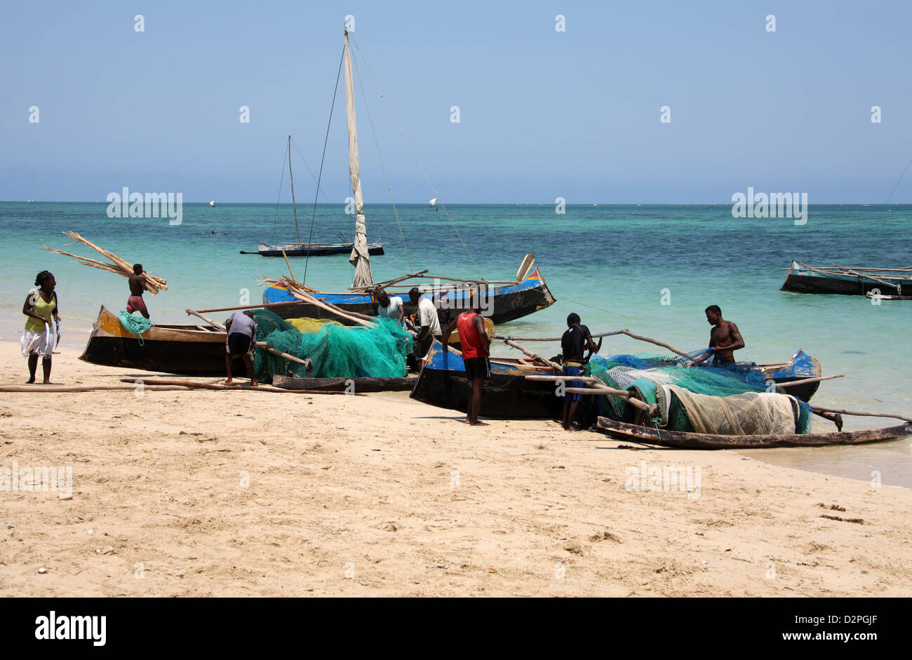 Pescatori malgasci e loro Outrigger piroghe. Anakao, Madagascar, Africa. Una piccola barca usata principalmente per la pesca. Foto Stock